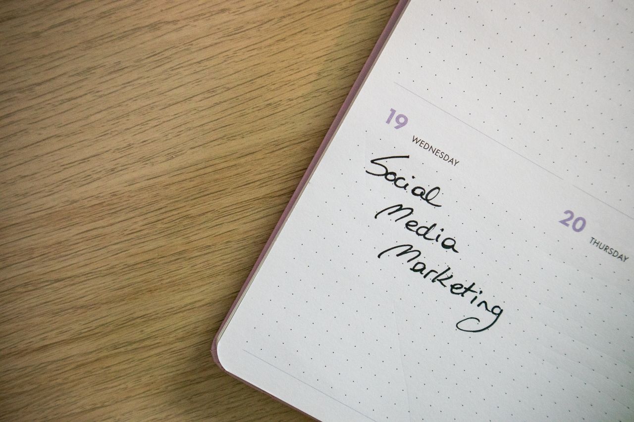 Gros plan sur une page de carnet où est écrit à la main Social Media Marketing.